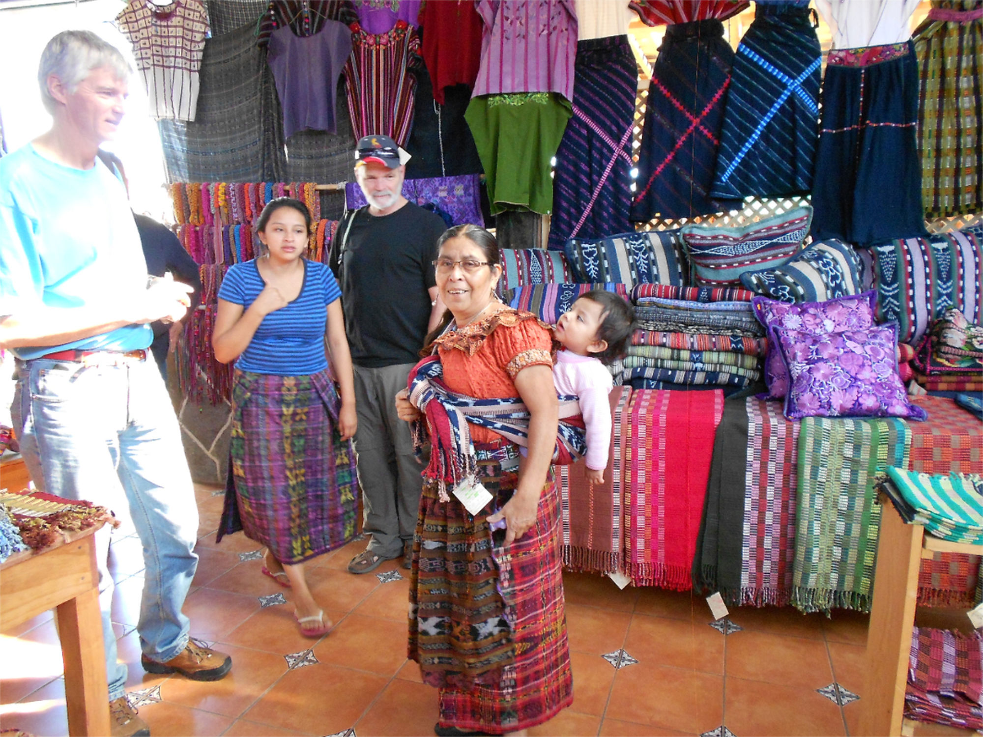 Groupe de personnes tenant un stand de textiles à un marché